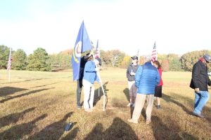 U.S. Navy Veterans and family members plant the U.S. Navy Flag at Veterans Day Tribute November 12, 2021