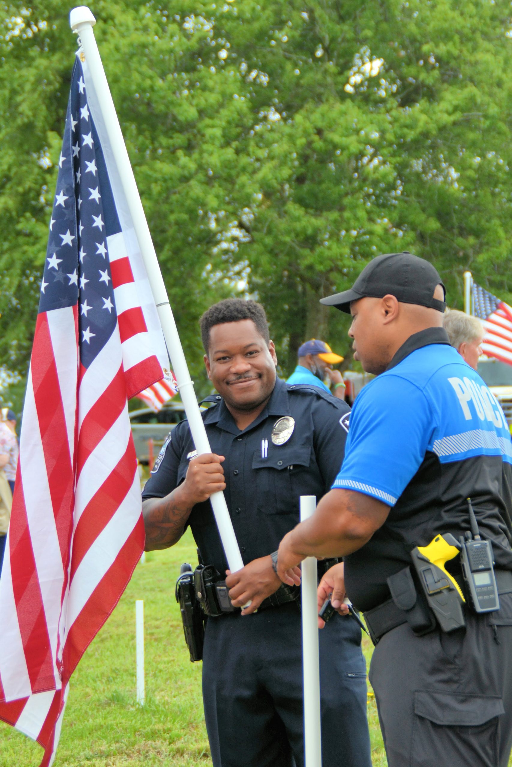 Clayton Police helping to raise flags. (Photo Credit Kristin Brown)