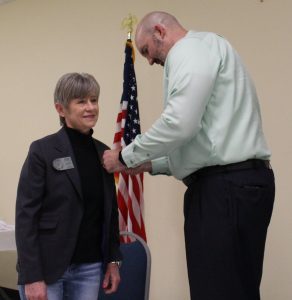 President Tara Abernathy receives her PHF+1 pin from Rotary Foundation Chair Mike Mullins.