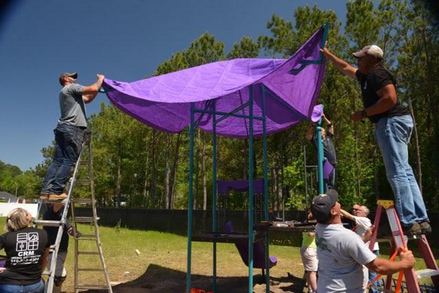 Putting the awning on the playground equipment.