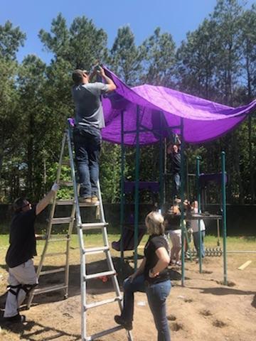 Putting the awning on the playground equipment.