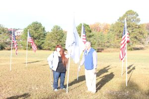 U.S. Coast Guard family member planting the U.S. Coast Guard flag in Veterans Day tribute November 12, 2021