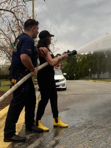 Clayton Rotary Club member Lynn Roman gets to try out the fire hose at the Clayton Rotary Club social at Clayton Fire Department Station 1